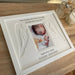 Shape of any angel wings mount in a frame on the tabletop next to a candle and diffuser