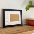 Single aperture black frame, star picture frame on wooden shelf