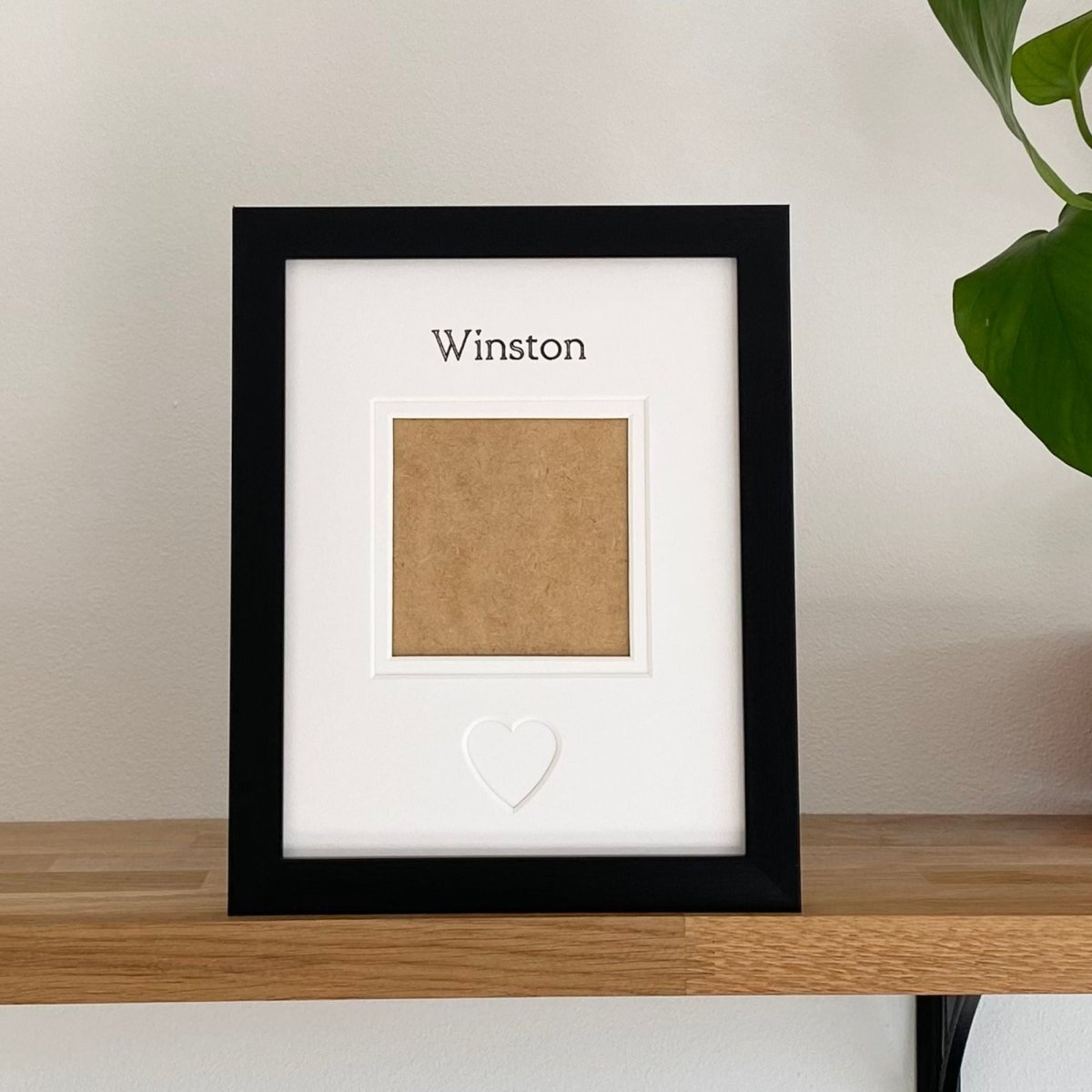 Framed picture with a name of cat or dog  'Winston' on a wooden surface