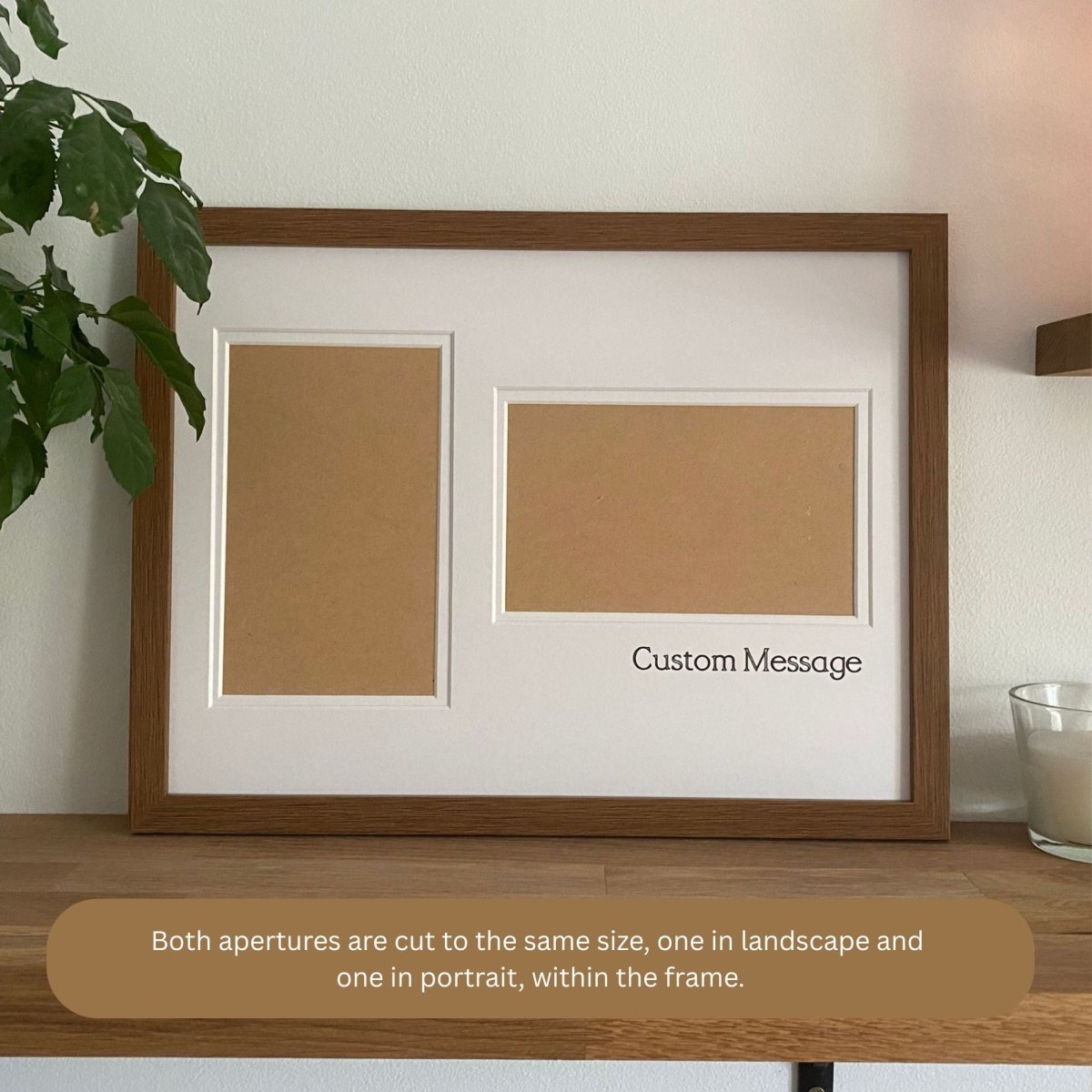 A large brown frame with white double matted, two aperture cut-out on a wooden shelf and white wall, green leafy plant and a white candle