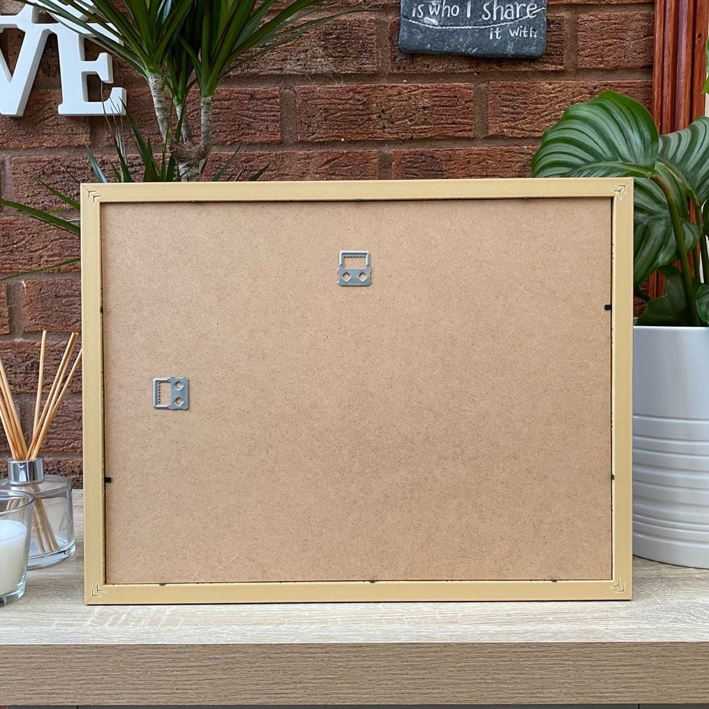 Back of 16x12 frame on shelf next to plant pot and diffuser, candle.