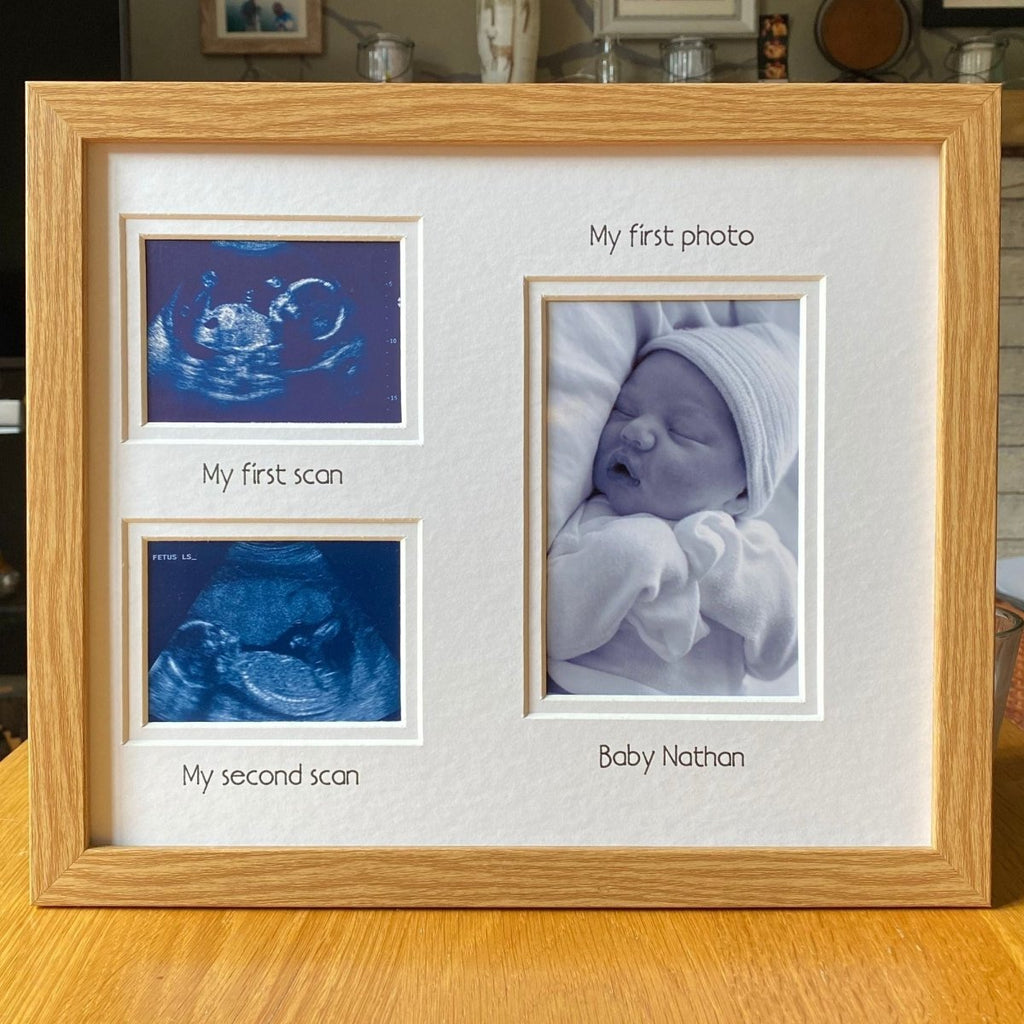 Light brown wood-grain effect photo frame with ultrasound images and baby photo on a wooden surface