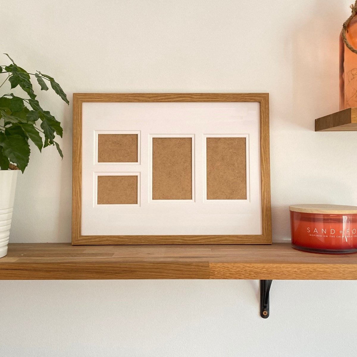 Light brown 4-aperture picture frame displaying empty family photos on wooden shelf 