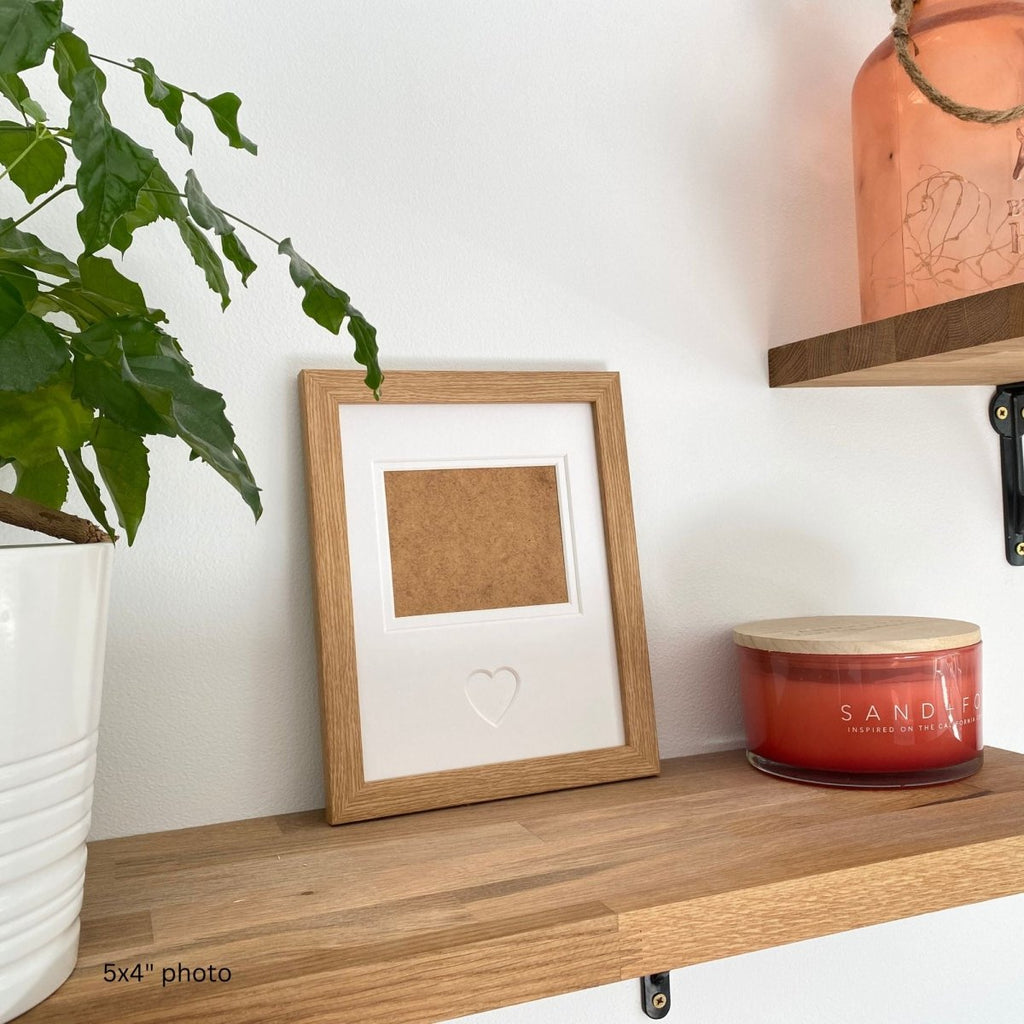 A single light brown heart picture frame set within a warm home setting