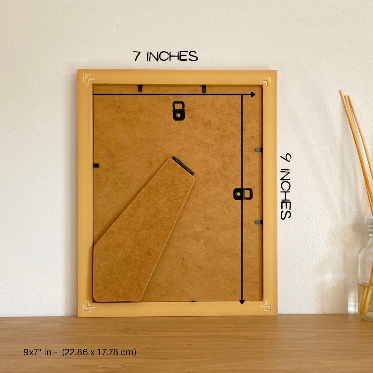 back of a brown frame on brown shelf against a white wall