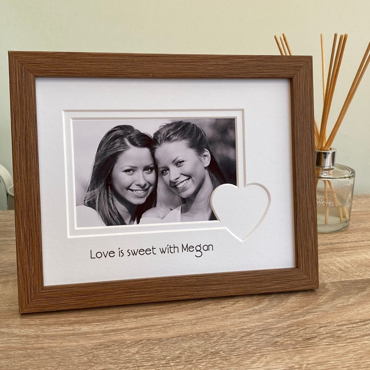 White heart mount and dark brown frame on grey shelf