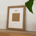 Light brown 1-aperture picture frame displaying a pet photo on wooden shelf