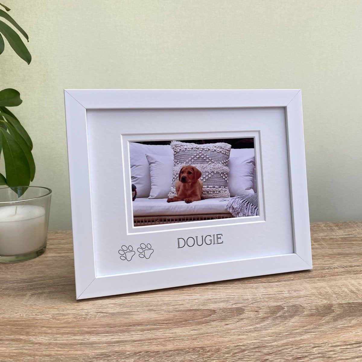White photo frame with a picture of a dog named Dougie on a wooden surface.