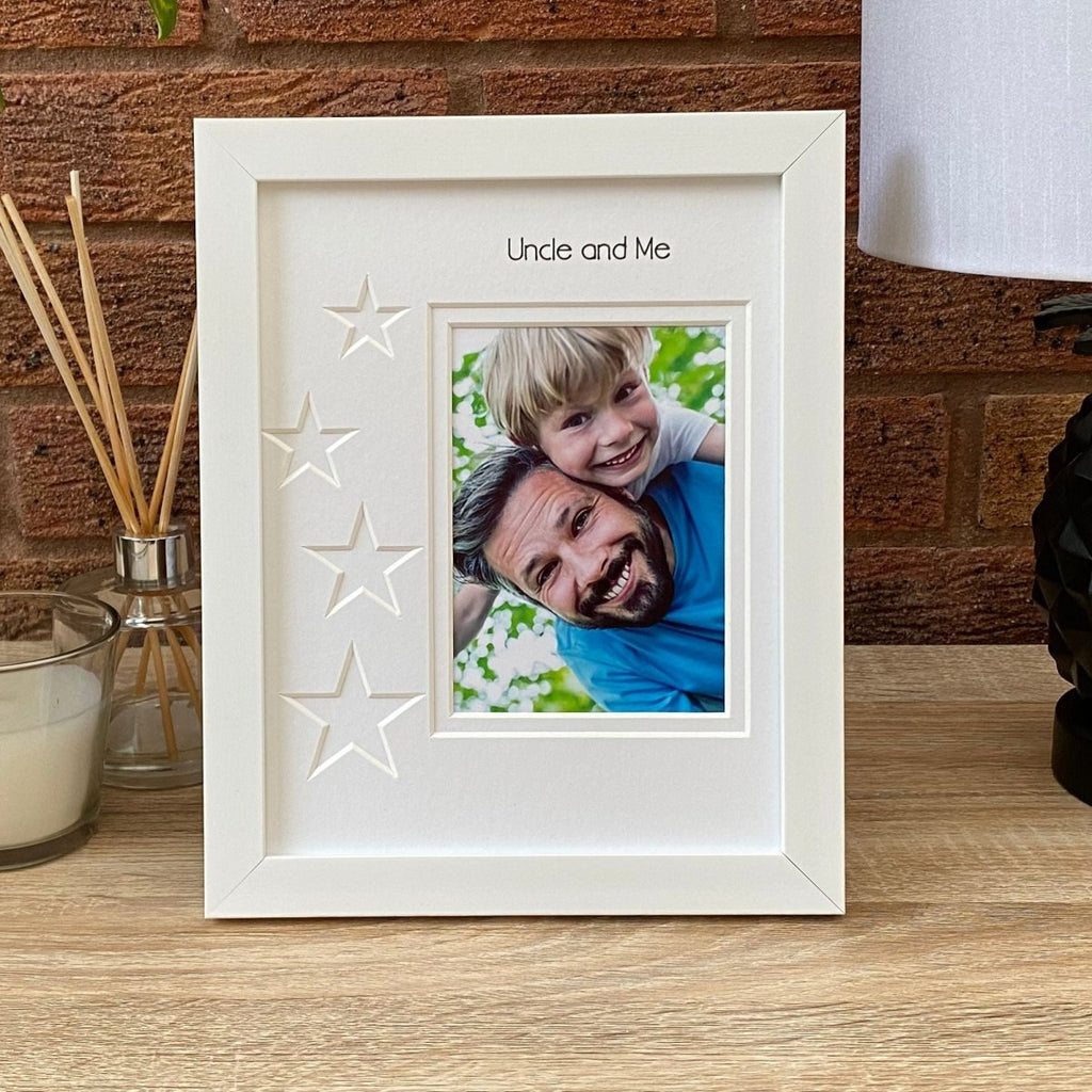 White portrait, single aperture picture frame star design on wooden table