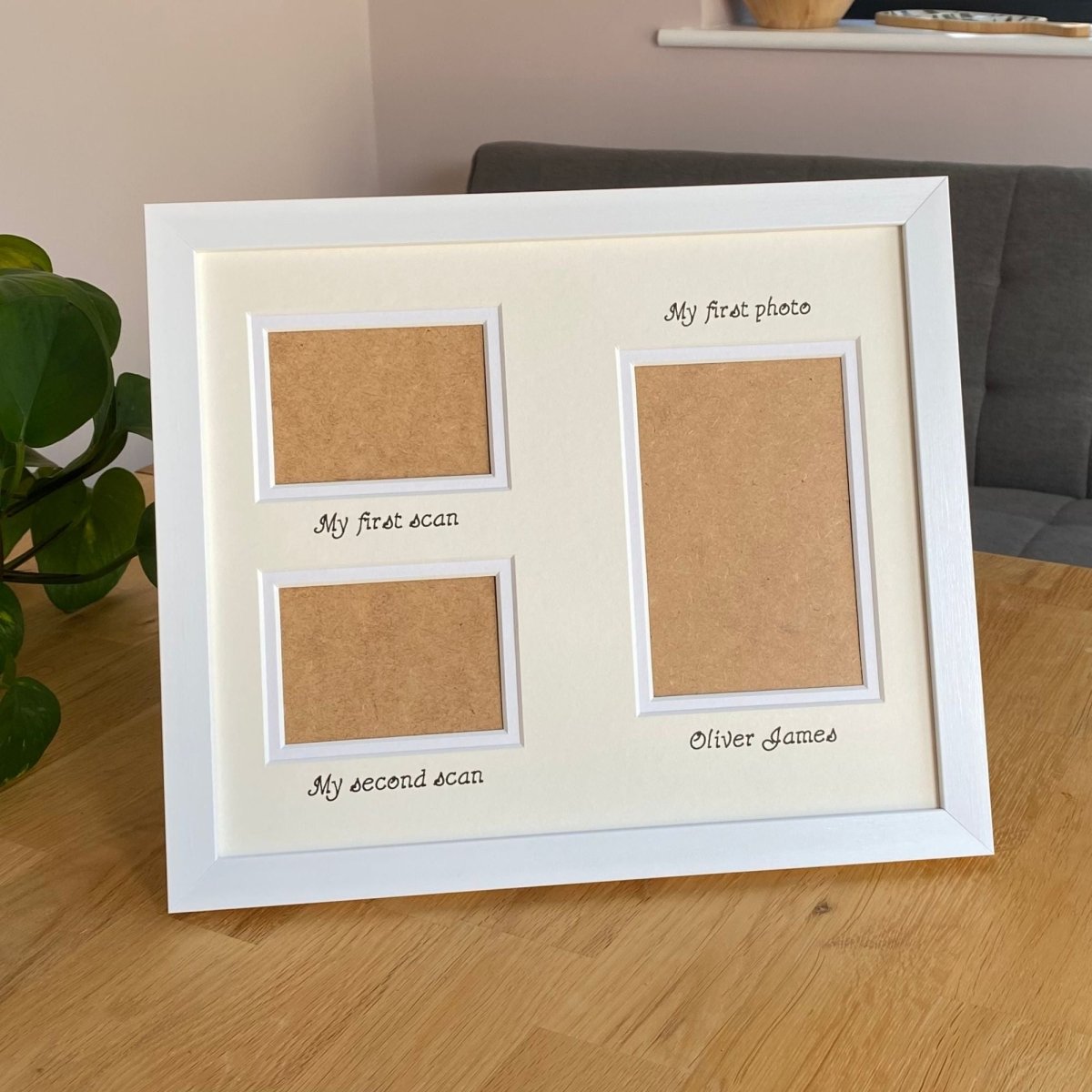 White photo frame with three apertures and text on a wooden surface.