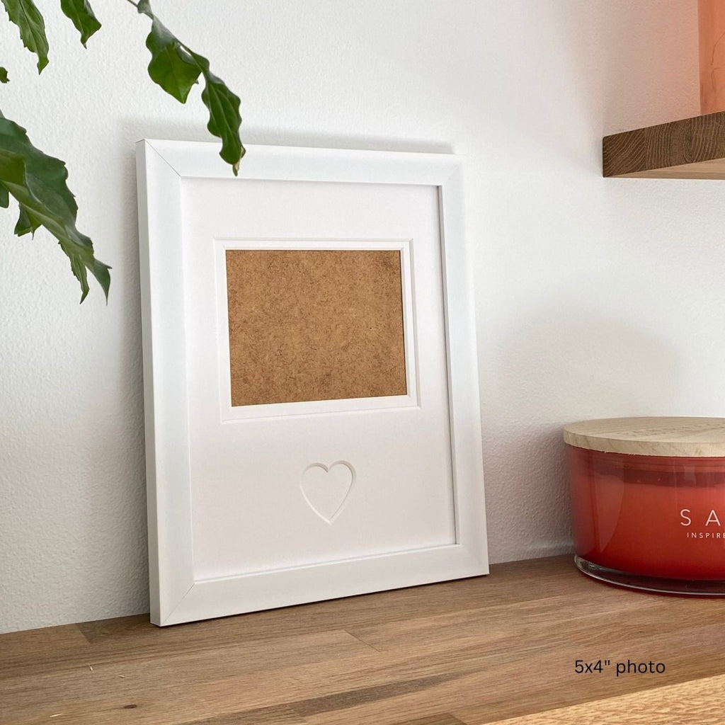 A single white heart picture frame lifestyle shot with home decor