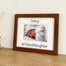 A picture of a baby Grandaughter in a dark brown photo frame on the shelf with her name personalised