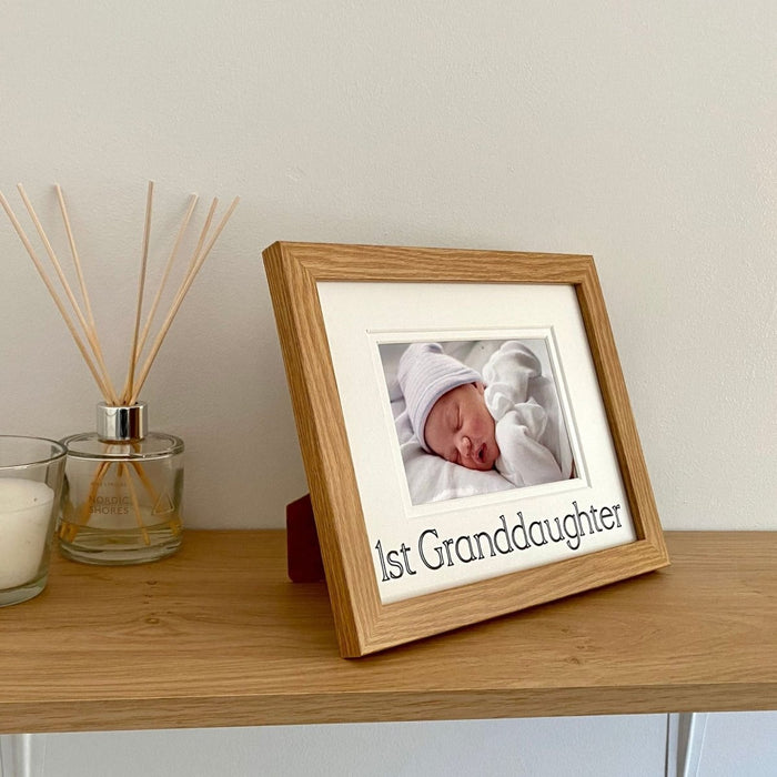 Freestanding 1st Granddaughter photo frame next to a white candle and diffuser on the shelf