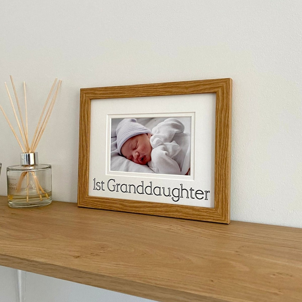 Photograph of a baby Granddaughter  in light brown picture frame on the shelf next to diffuser