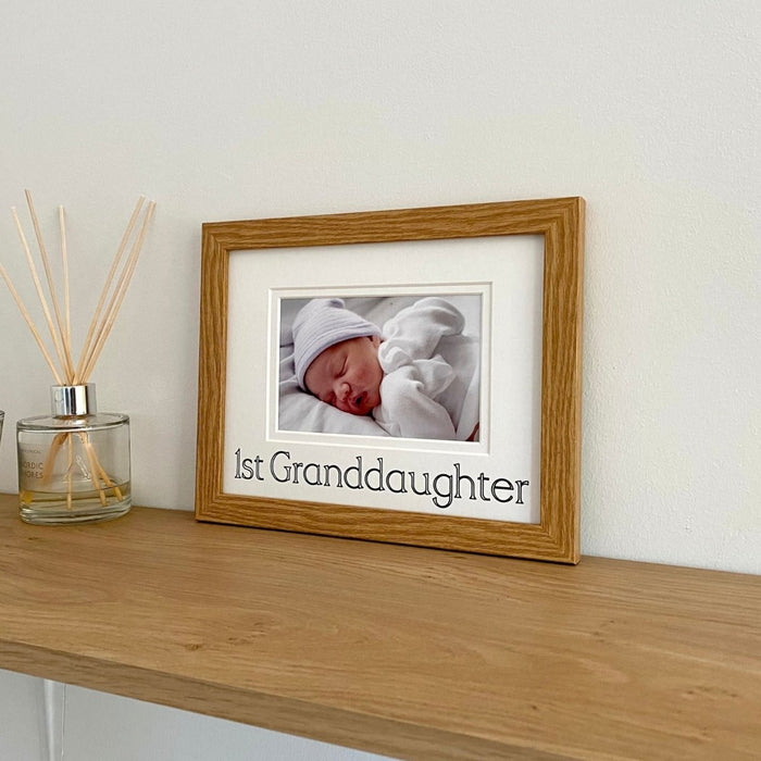 Photograph of a baby Granddaughter  in light brown picture frame on the shelf next to diffuser