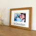 Light brown picture frame of first Grandson on shelf next to diffuser