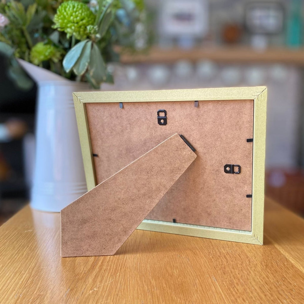 Picture Frame on coffee table next to white flower jug