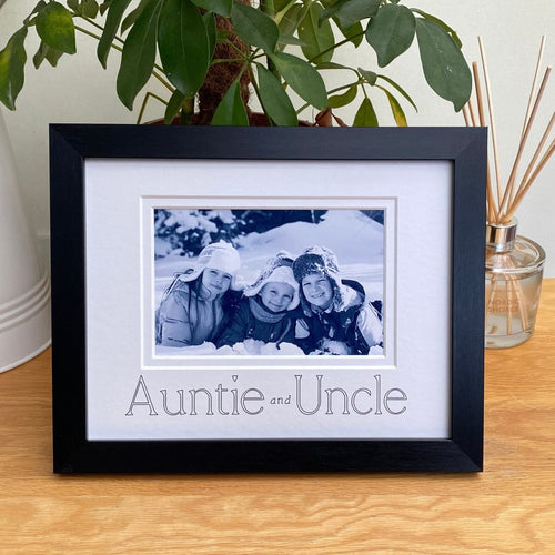 A photo of the children in a black picture frame on the tabletop next to a diffuser and green plant behind
