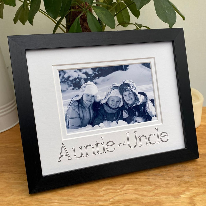 A landscape photograph of the children in a black Auntie and Uncle picture frame on the tabletop