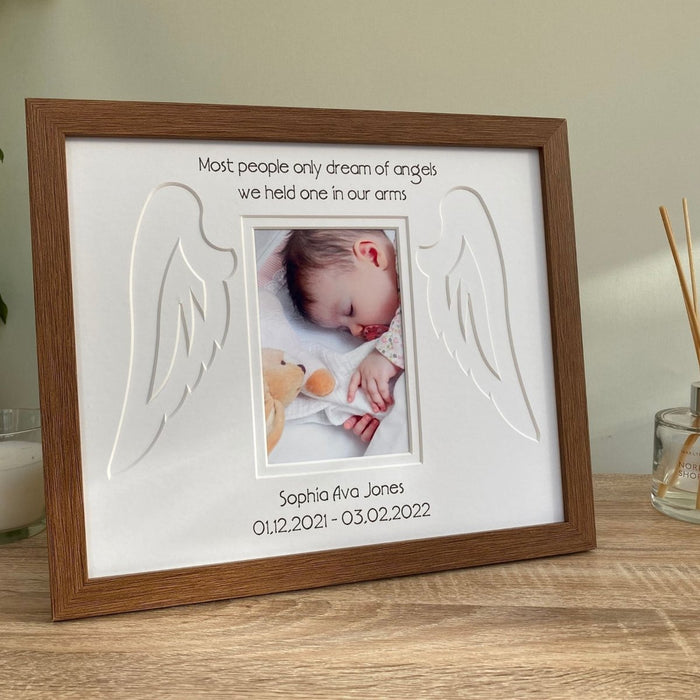 Freestanding Dark brown picture frame of angel wings on tabletop