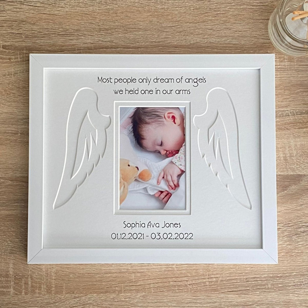 A picture of a baby in a white memorial funeral frame on the tabletop