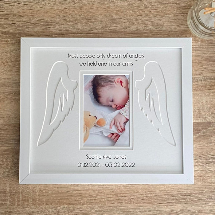 A picture of a baby in a white memorial funeral frame on the tabletop
