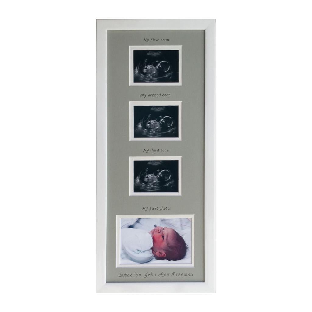 White frame with a grey picture mount showing scanned images and baby