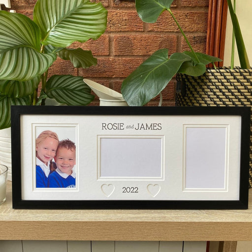 Black, Multipicture school frame on tabletop next to a green plants