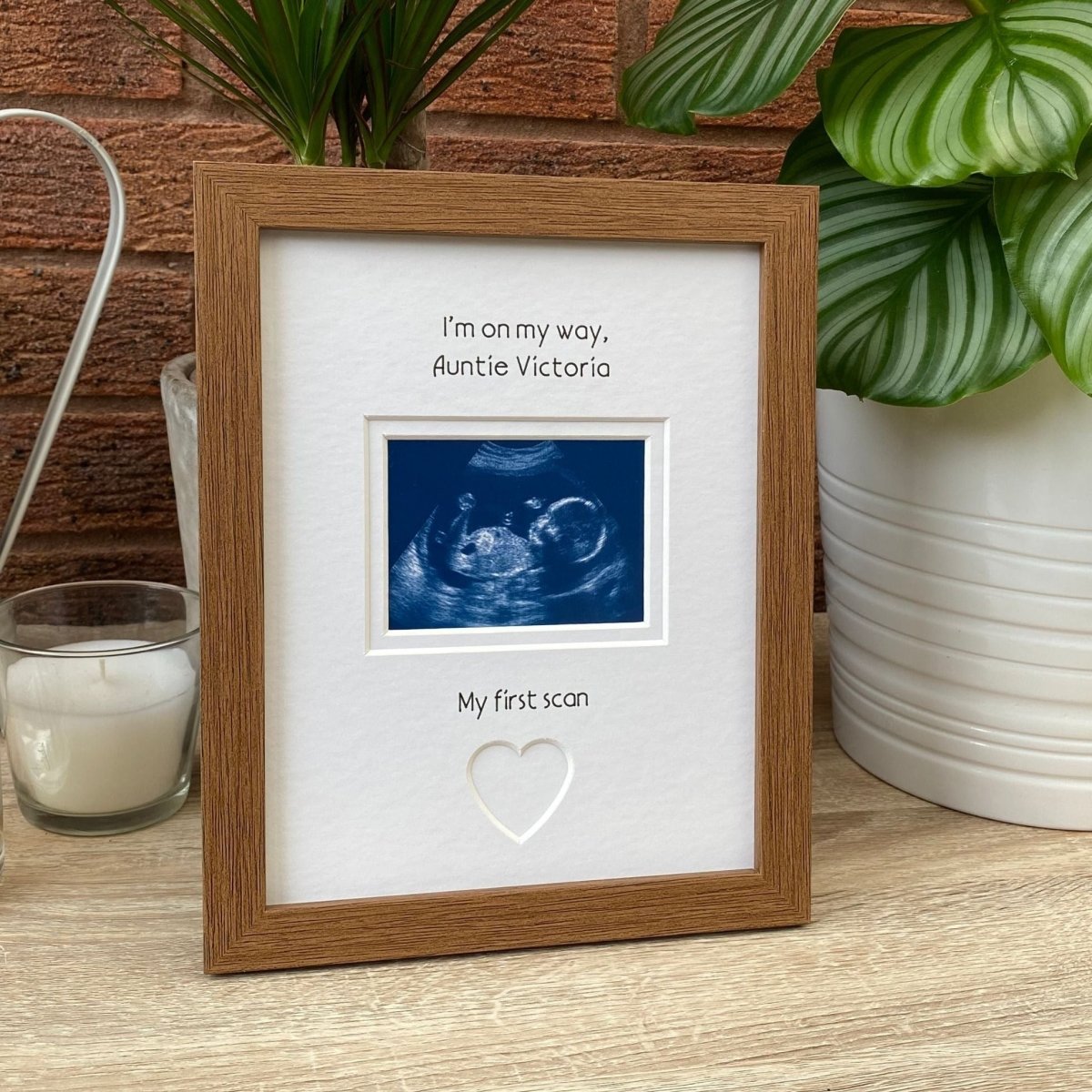 Auntie scan picture frame on tabletop next to a plant and candle