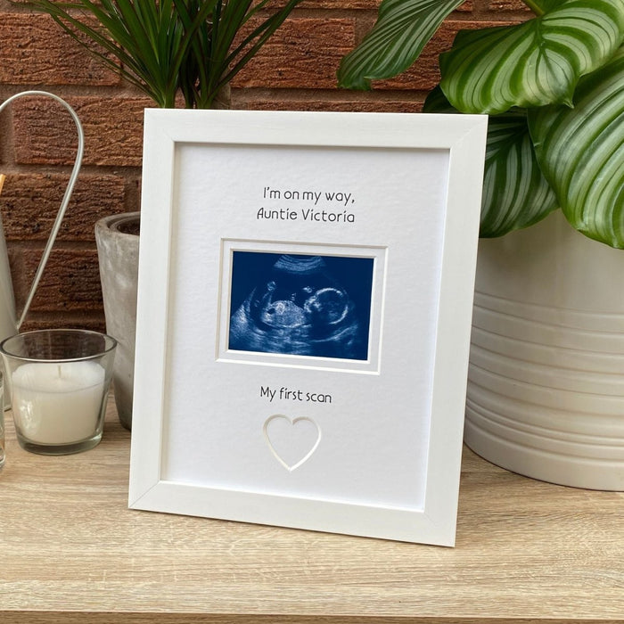 White frame, scan image on tabletop next to a white candle and plant