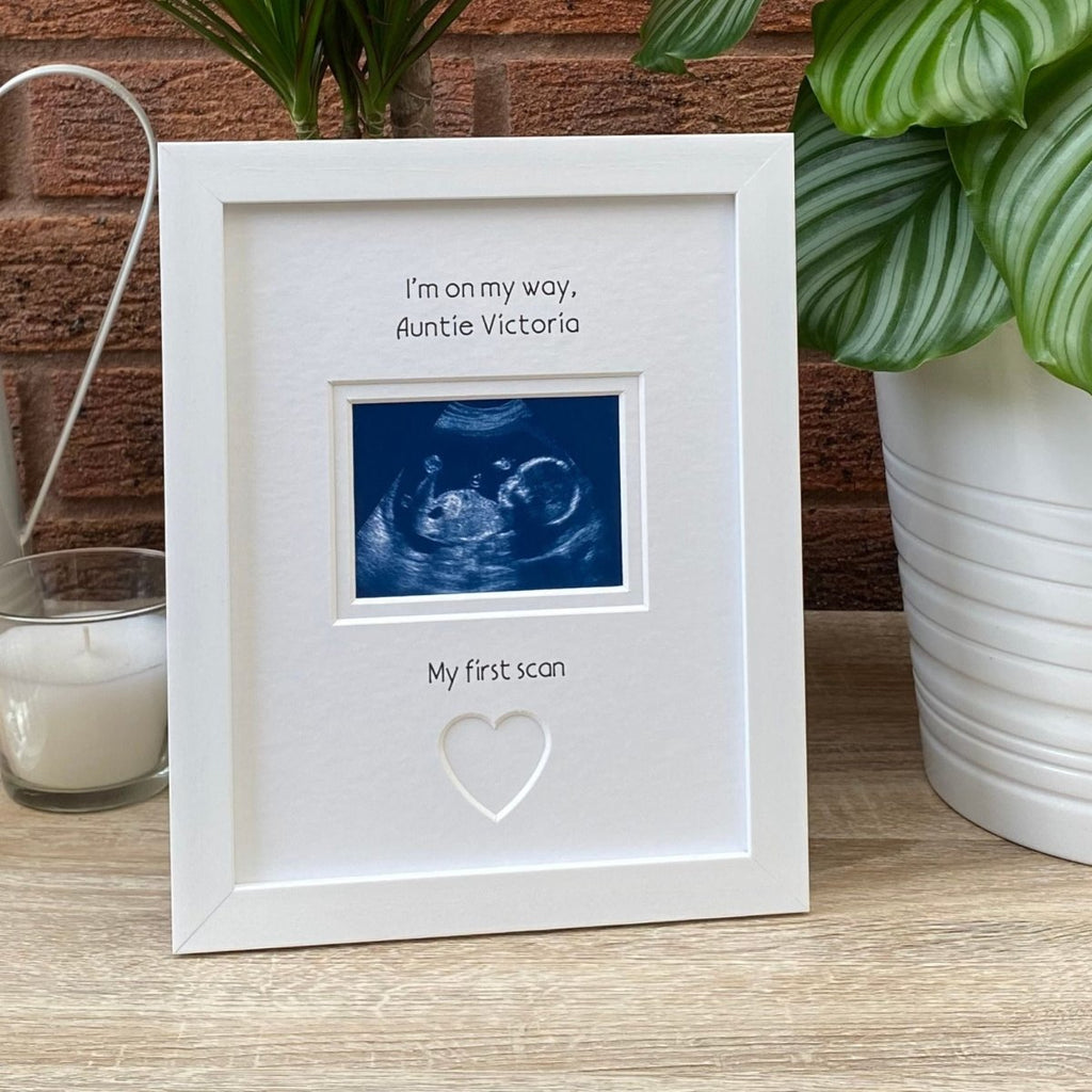 White frame, scan image on tabletop next to a white candle and plant