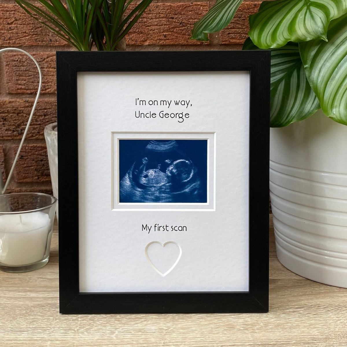 Black frame for Uncle to be on tabletop, next to a candle and plant