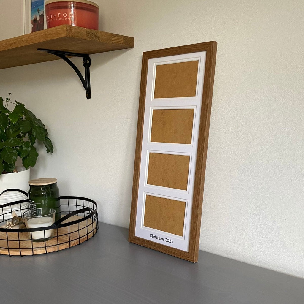 Dark brown frame with white mount on grey dresser next to a black mesh tray with candles and plant, shelf on wall. Personalise with any message to be inscribed at the bottom of the mount - Azana Photo Frames