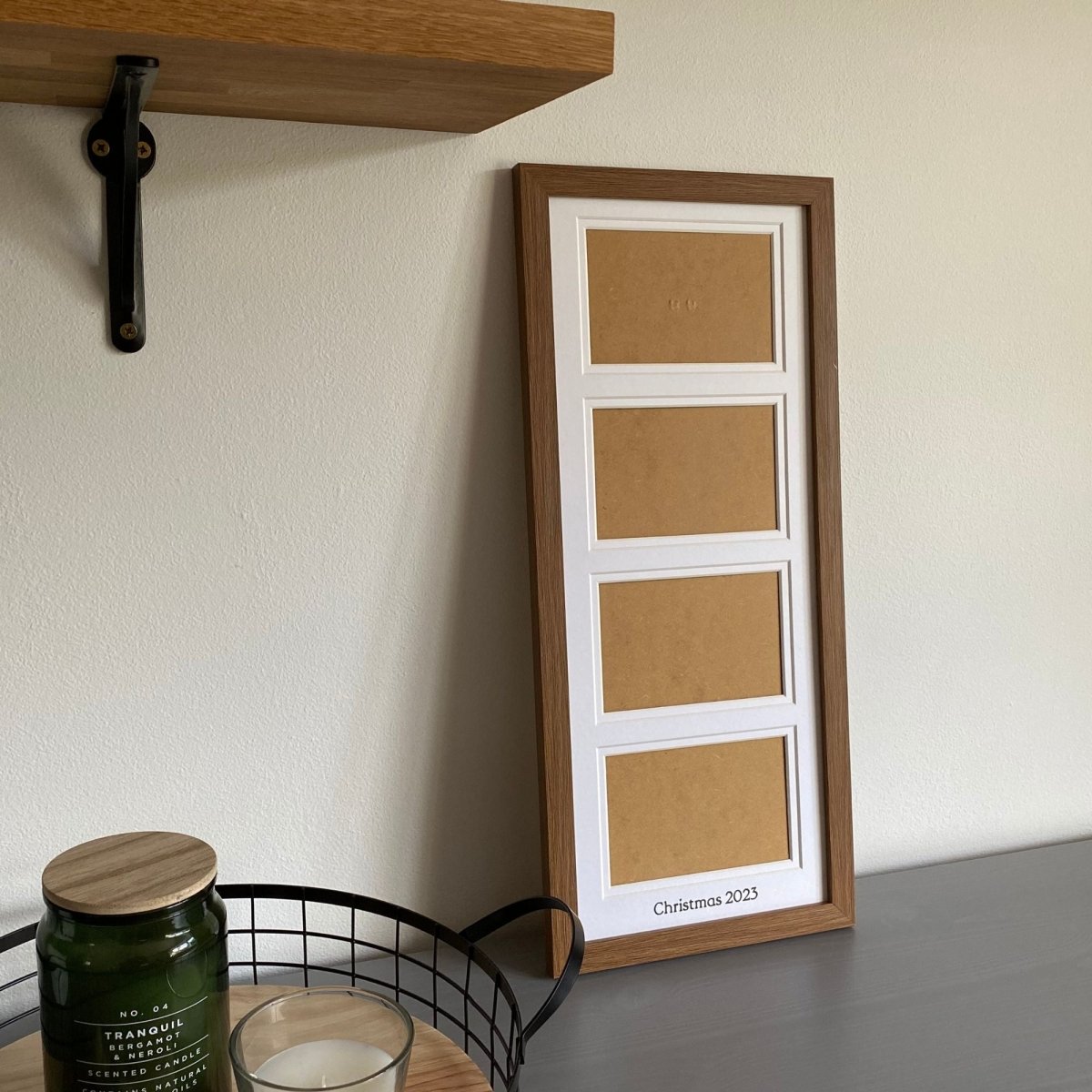Dark brown frame with white mount on grey dresser next to a black mesh tray with candles - Azana Photo Frames