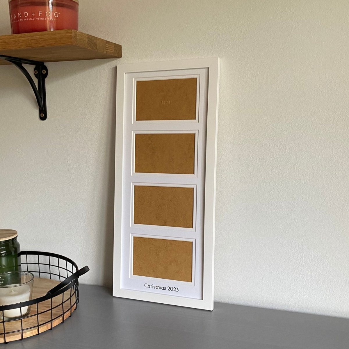 Multi Landscape Aperture Frame 4 Photos, White - holds four landscape photograph on grey tabletop next to black mesh tray and shelf with candles - AZana Photo Frames