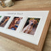 Light brown multipicture frame of family pet dogs on the tabletop next to a white candle