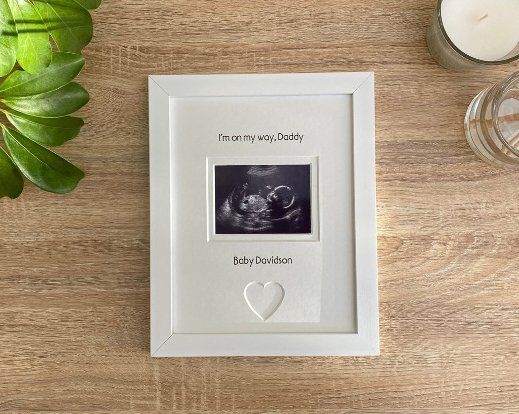White picture scan photo frame for new Daddy next to a white candle and plant on the table top