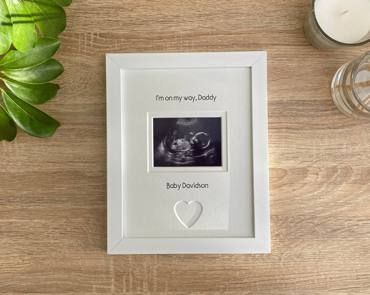 White picture scan photo frame for new Daddy next to a white candle and plant on the table top