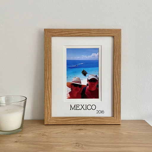 Holiday picture frame on a shelf next to a candle