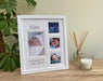 Baby Collage white modern picture frame, freestanding on the tabletop next to a white candle, diffuser and green plant