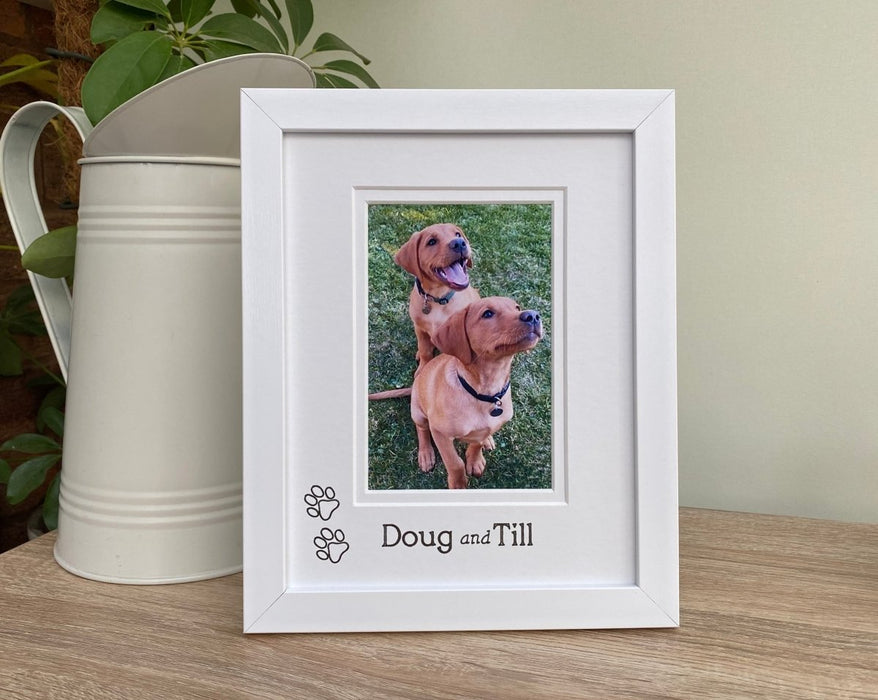 White picture frame, image of two puppies and custom personalisation next to a jug on the tabletop