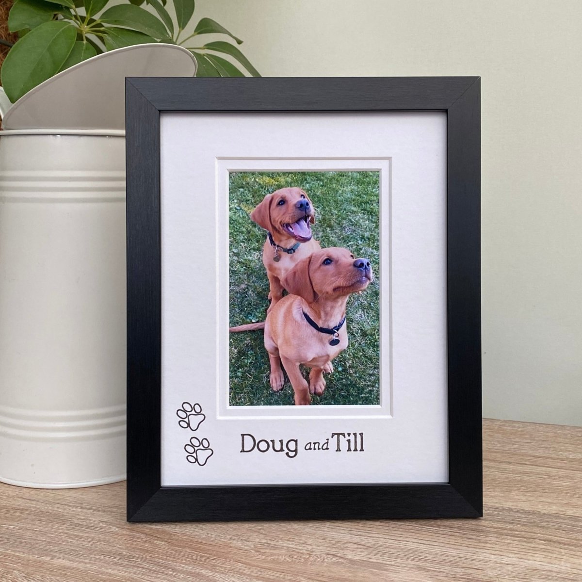 black photo frame, with a double white matted and custom personalisation, freestanding next to a jug and plant.