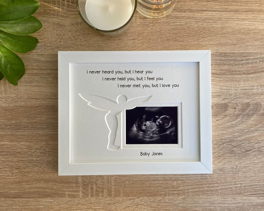White picture frame displaying a baby scan image with the verse, I never heard you, but I hear you. I never held you, but I feel you, I never met you, but I love you