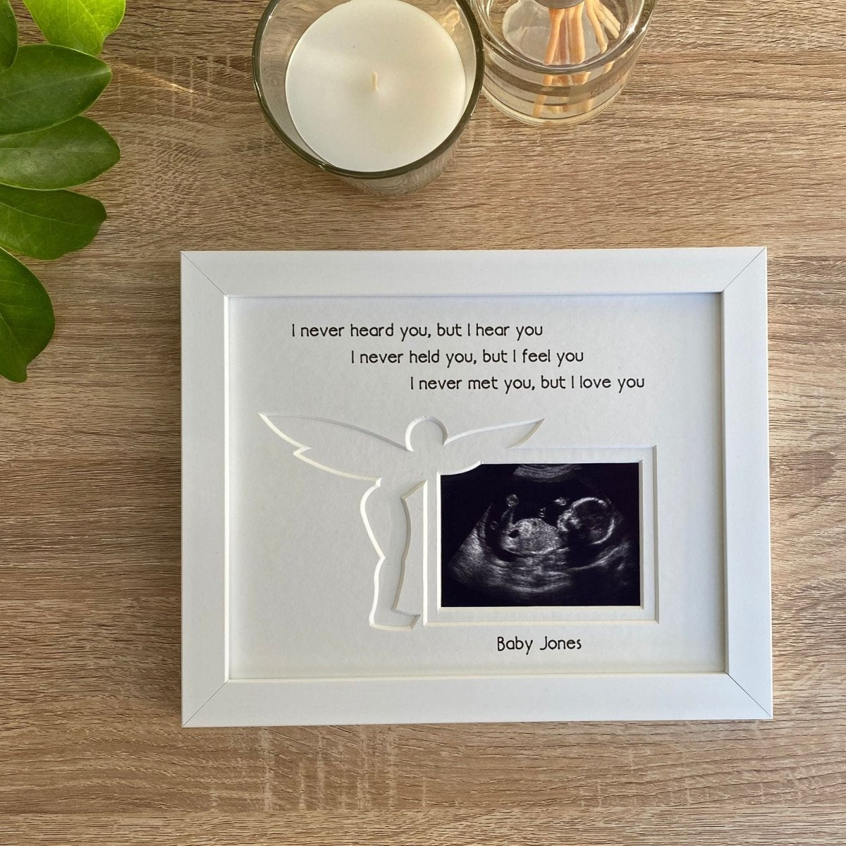 White picture frame displaying a baby scan image with the verse, I never heard you, but I hear you. I never held you, but I feel you, I never met you, but I love you and custom personalisation with your baby's surname inscribed - Baby Jones