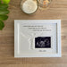 White picture frame displaying a baby scan image with the verse, I never heard you, but I hear you. I never held you, but I feel you, I never met you, but I love you and custom personalisation with your baby's surname inscribed - Baby Jones