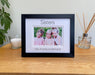 Black picture frame, double white matted with the Sisters inscribed and personalised with all the sister's names. Standing next to a white candle on the table top with a plant on the side.