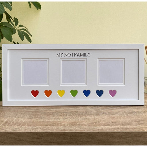 White picture landscape frame with three apertures and rainbow heart shaped resting on the floating shelf