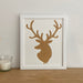 stag picture frame next to white candle on a shelf
