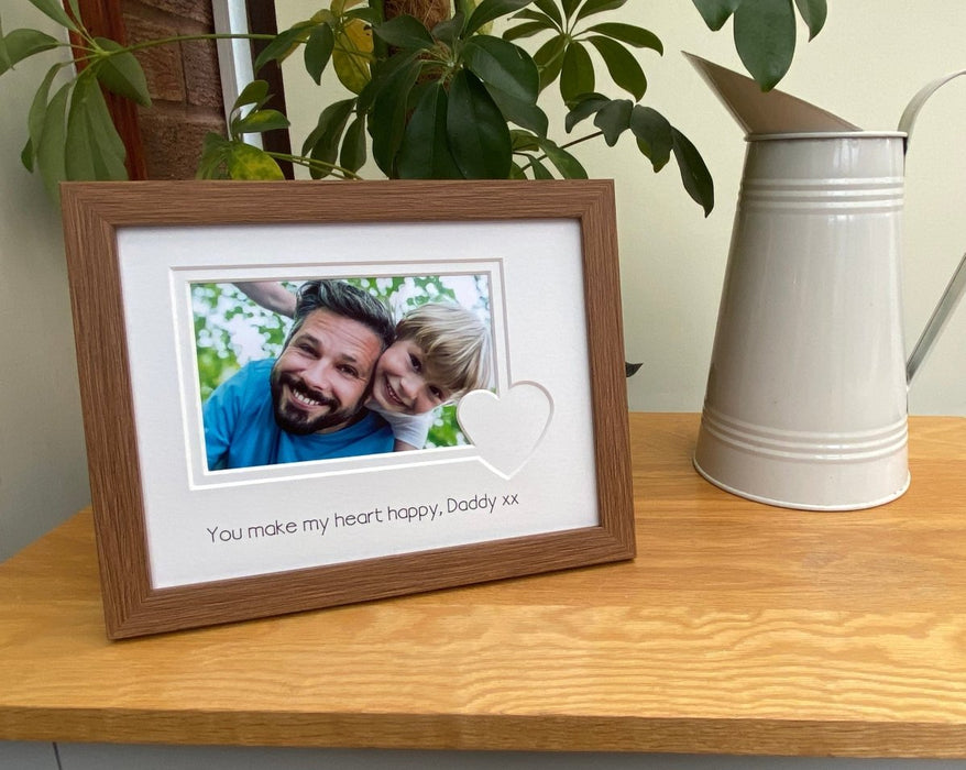 Dark brown love heart picture frame on the tabletop, an image of a Father and son